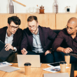 multiracial business colleagues working on new business idea in cafe