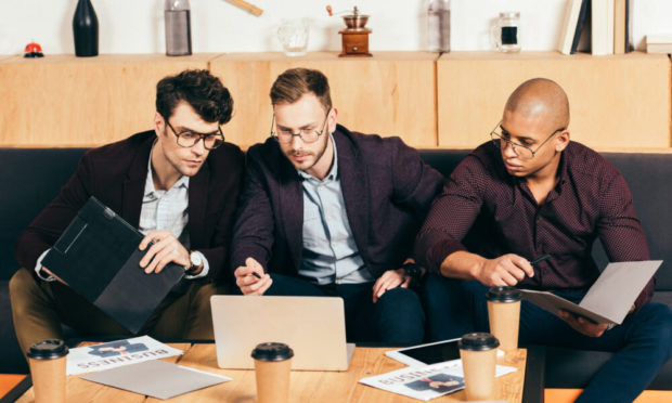 multiracial business colleagues working on new business idea in cafe
