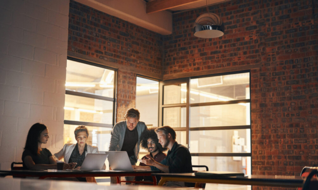 Team working together on laptops to support ERP implementation, digital transformation and NetSuite and Sage software projects.