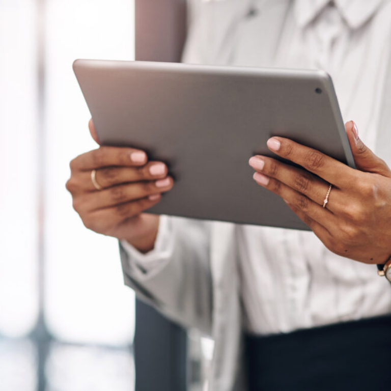 Businesswoman in professional attire reviewing data on a tablet